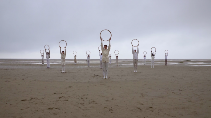 De dansers houden hun houten cirkel boven hun hoofden.