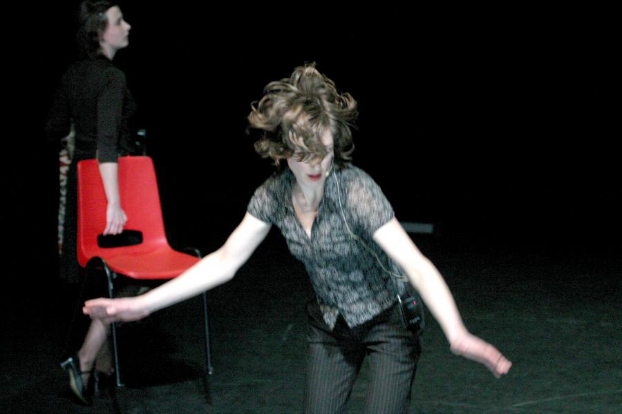 Vrouw danst naast rode stoel